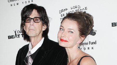 Paulina Porizkova in a black dress poses with ex-husband Ric Ocasek.